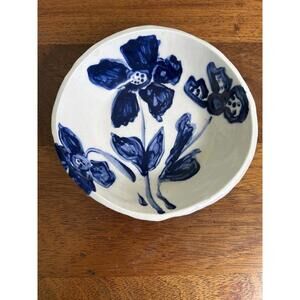 Handmade pottery bowl featuring a blue floral pattern